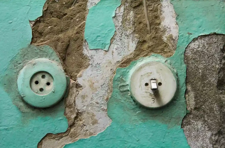 Vieille prise électrique non conforme dans une maison ancienne à rénover